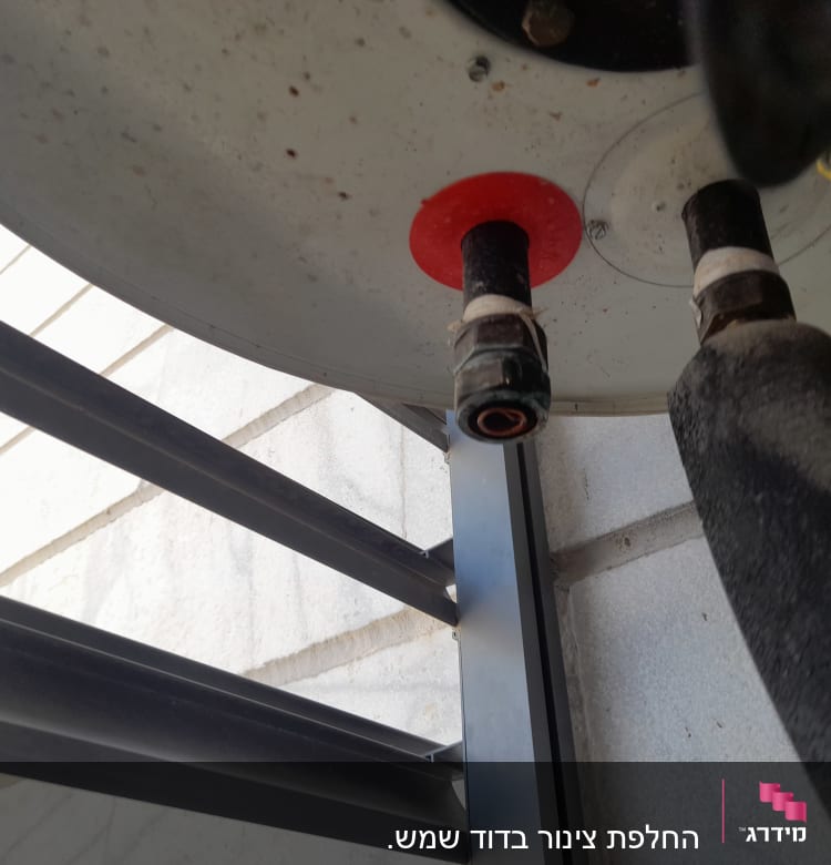 צינורות מחוברים לדוד שמש על גג